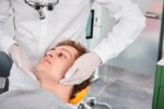 Dr. Kamyab Banitorfi untersucht bei einem Patienten die Gesichtsmuskulatur und Kieferbewegung zur Funktionsdiagnostik.